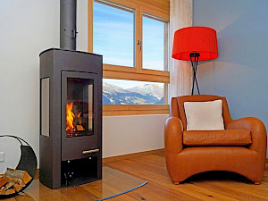Appartement Ski Heaven Veysonnaz Zwitserland woonkamer met houtkachel